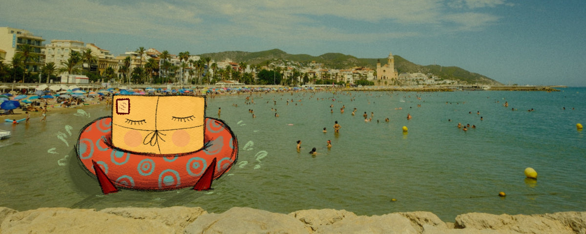 Vintage-style photograph of Sitges beach in Spain with swimmers, palm trees, and the historic waterfront