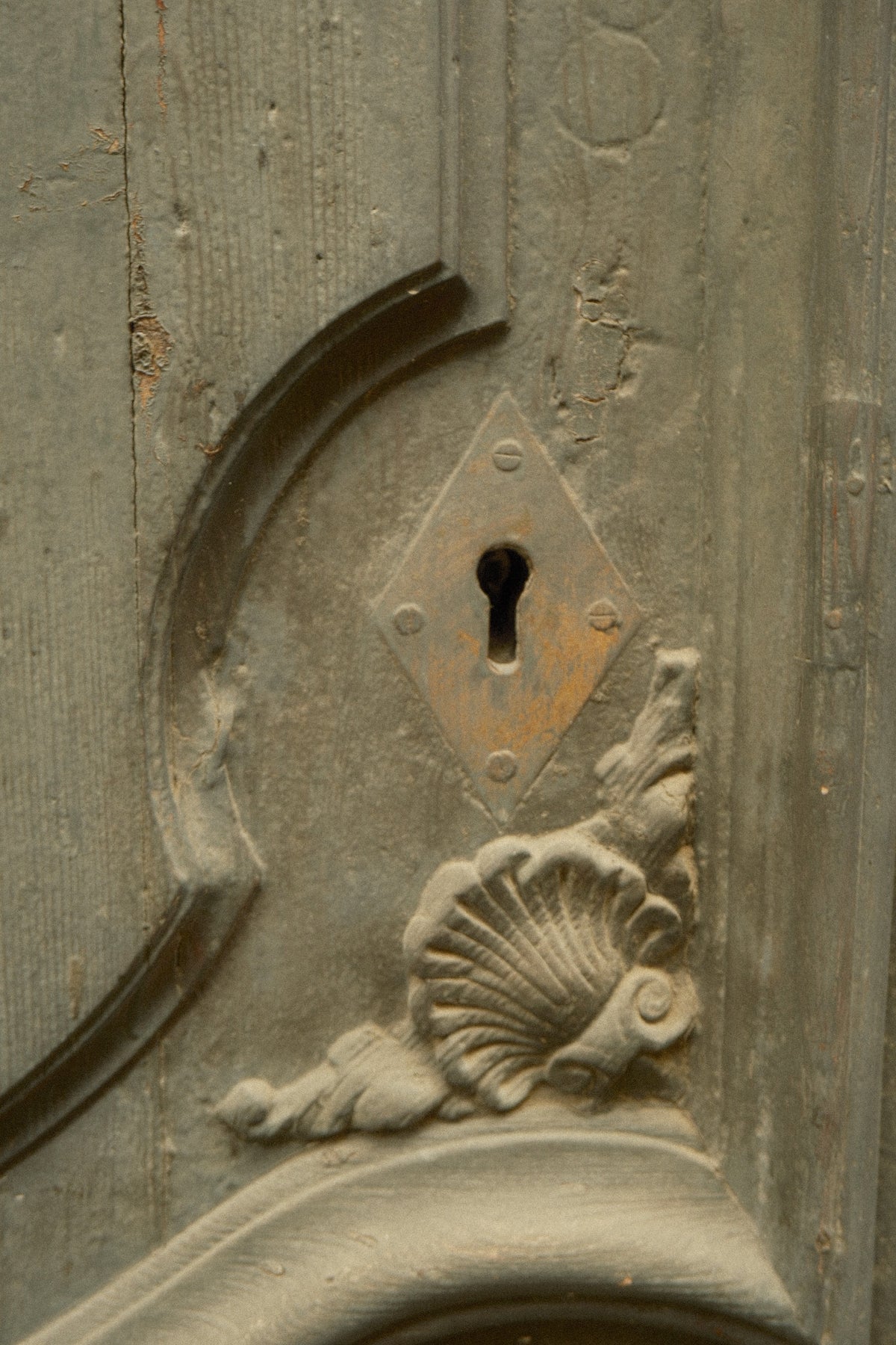 Vintage decorative keyhole and shell detail on a door in Sitges, Spain