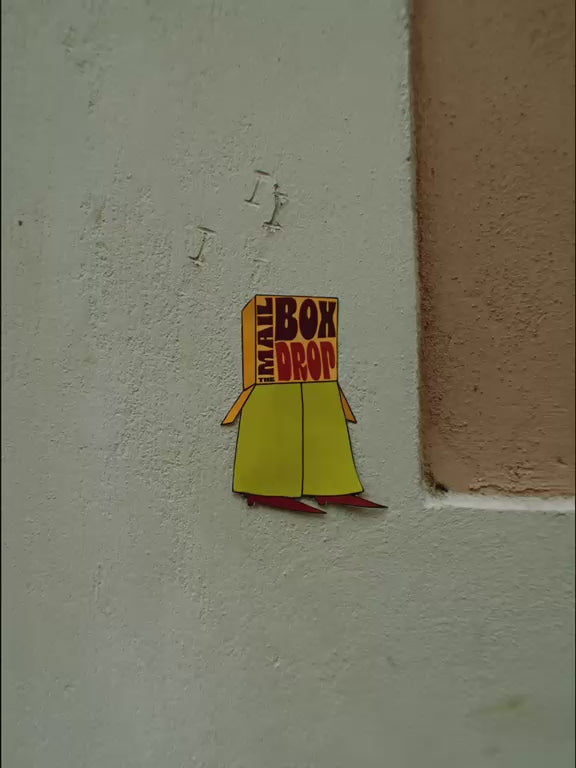 The Mailbox Drop logo appearing on colorful textured walls and surfaces around Barcelona.